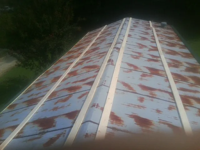 Rusted metal roof panels with new wood purlins before replacement — Storm Damage Roof Repair in Burtrum by Roofing Brothers